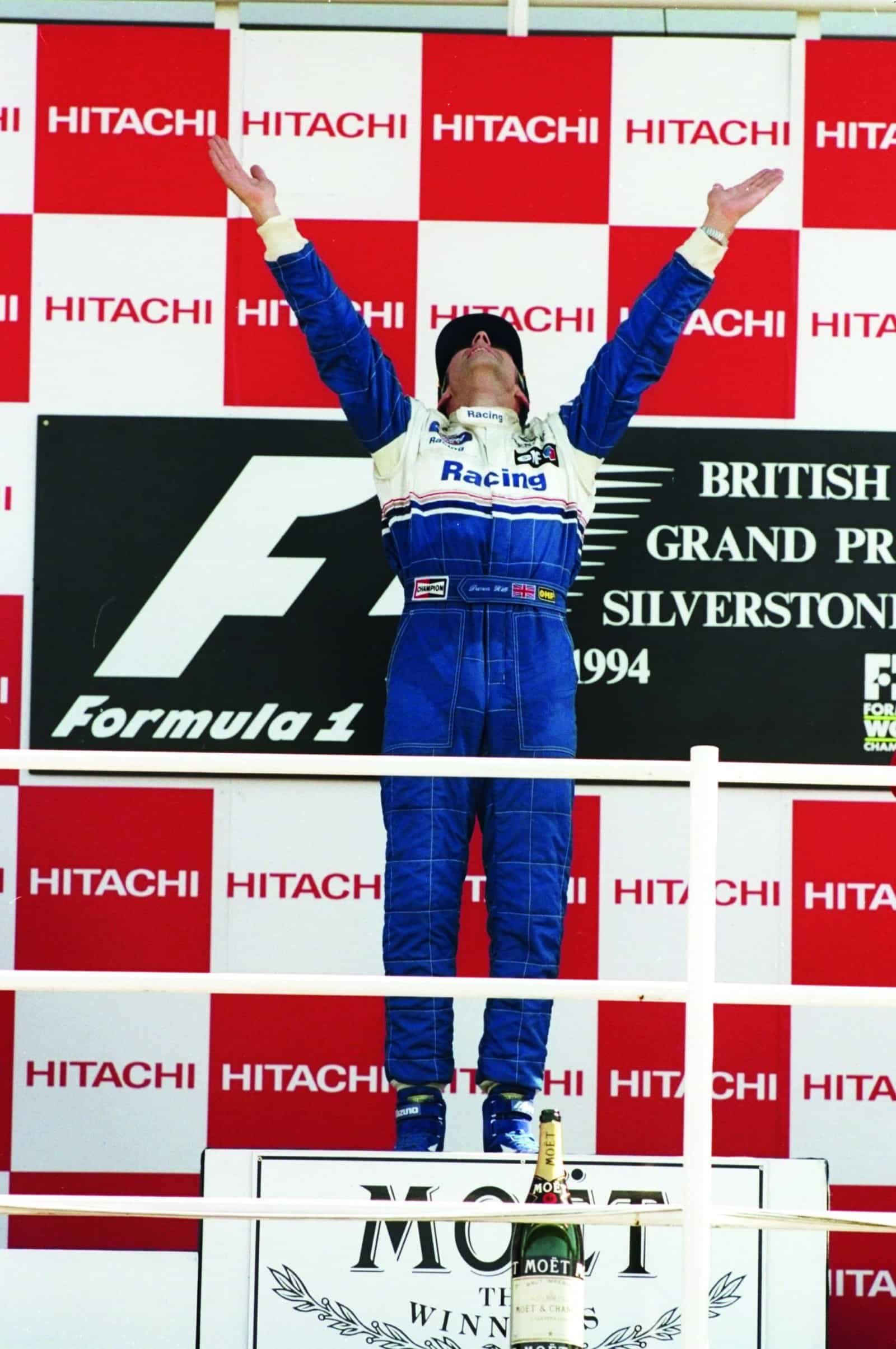 Damon-Hill-raises-his-hands-to-the-air-on-the-podium-after-winning-the-1994-F1-British-Grand-Prix-at-Silverstone