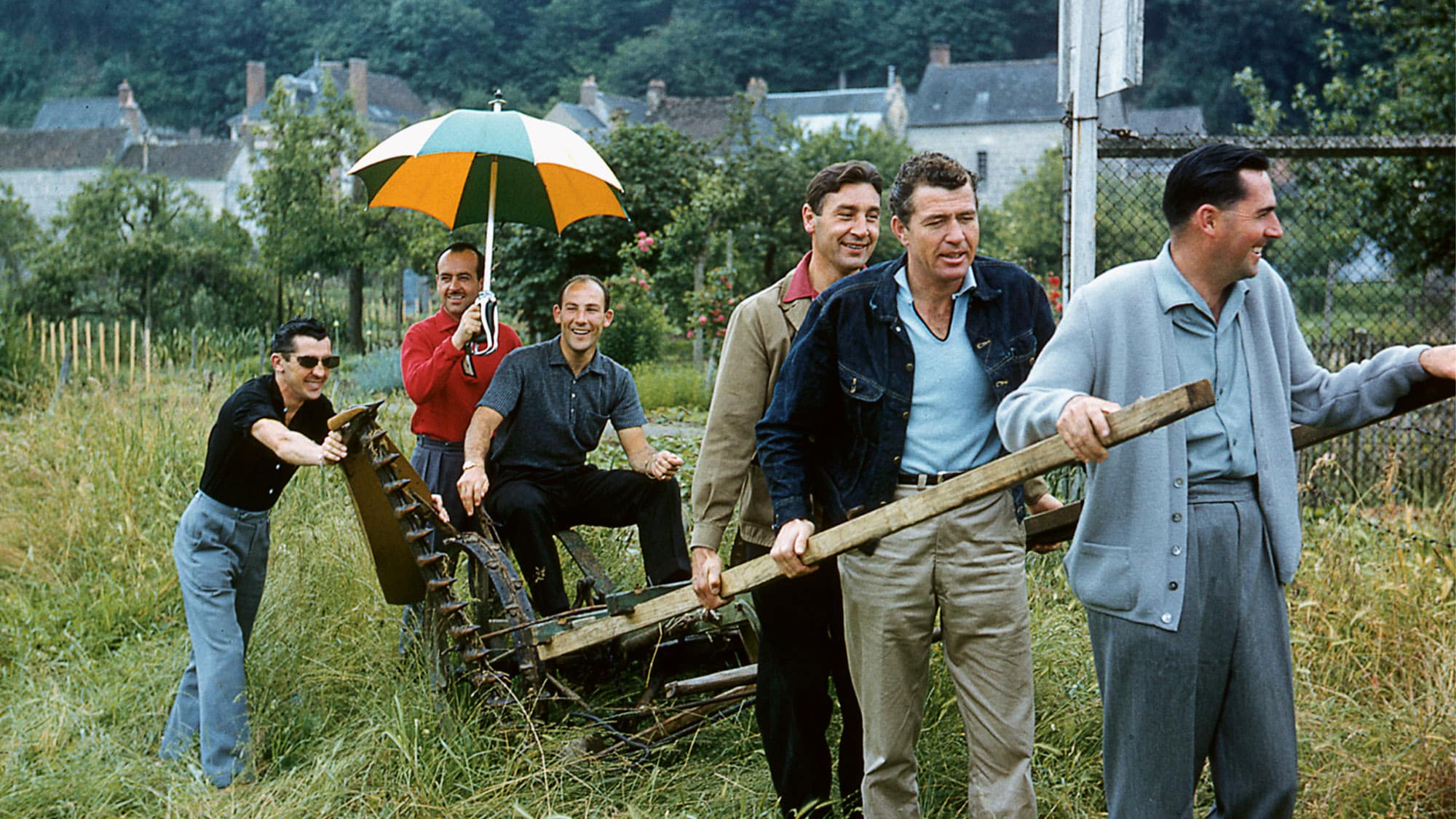 Jack Brabham, Caroll Shelby and Roy Salvadori pulling a cart with Stirling Moss and Maurice Trintignant