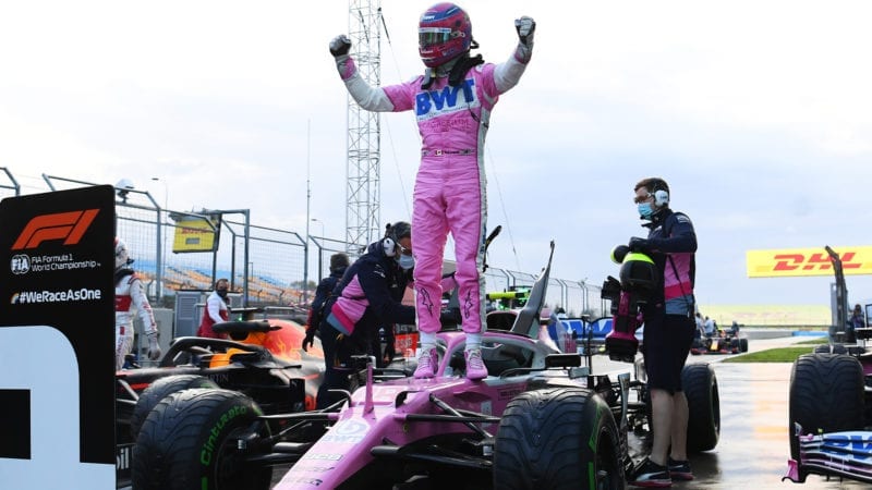 Lance Stroll celebrates taking pole position for the 2020 F1 Turkish Grand Prix, standing on his Racing Point after qualifying