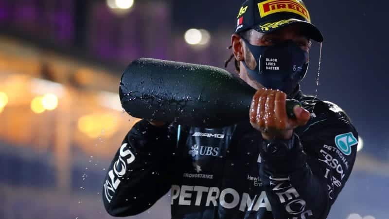 Lewis Hamilton holds up a champagne bottle after winning the 2020 F1 Bahrain Grand Prix
