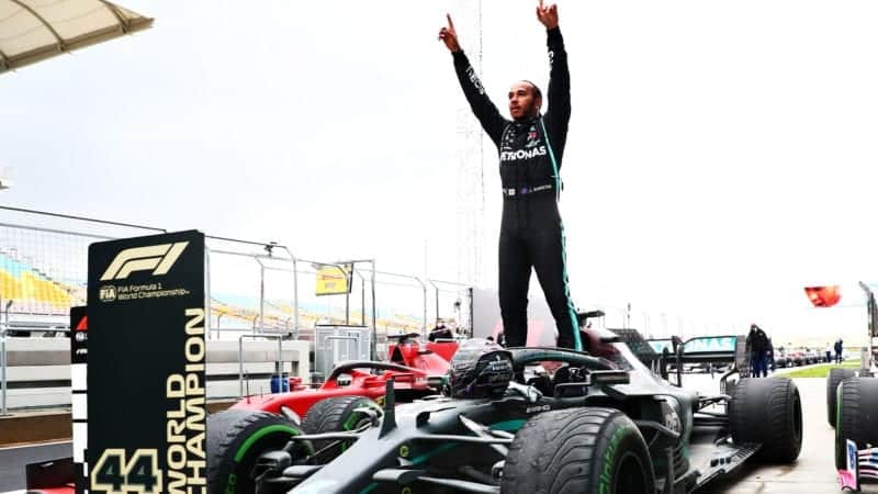 Lewis Hamilton raises his arms in the air as he celebrates winning the 2020 F! World Championship and the Turkish Grand Prix