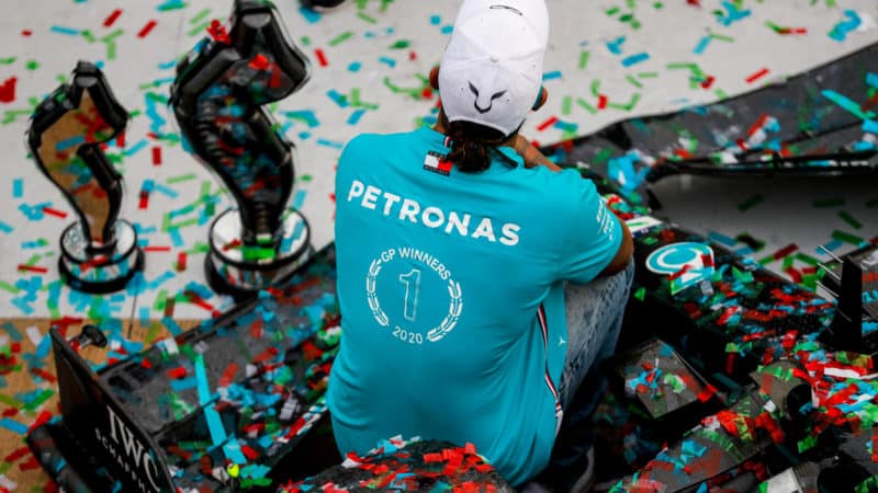 Lewis Hamilton sits on his Mercedes covered in ticker tape after clinching the 2020 F1 constructors championship at Imola
