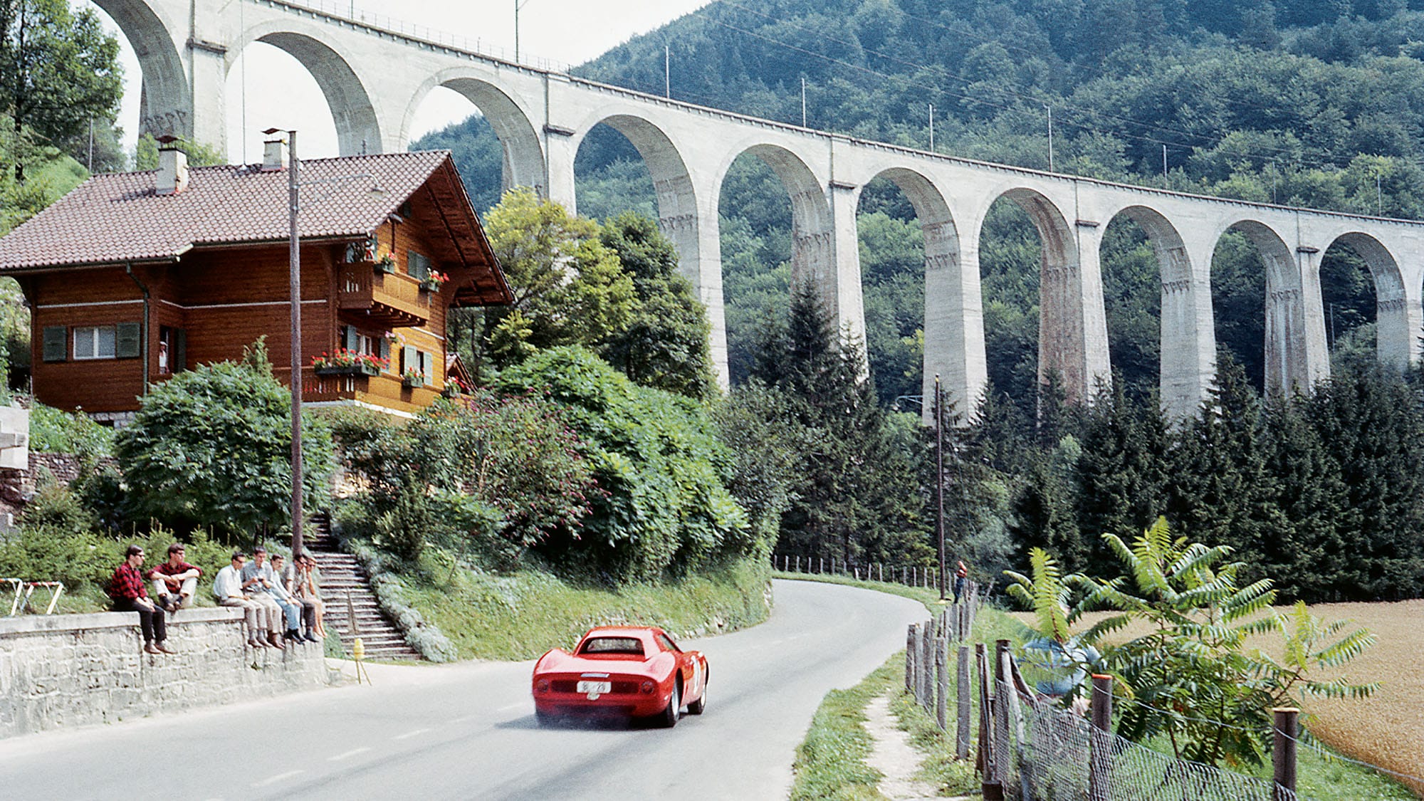 Ludovico Scarfiotti's Ferrari 250LM drives to victory under a railway bridge in the 1964 Grosser Bergpreis der Schweitz