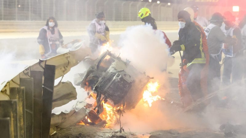 The front part of Romain Grosjean's wrecked Haas on fire and embedded in the barrier