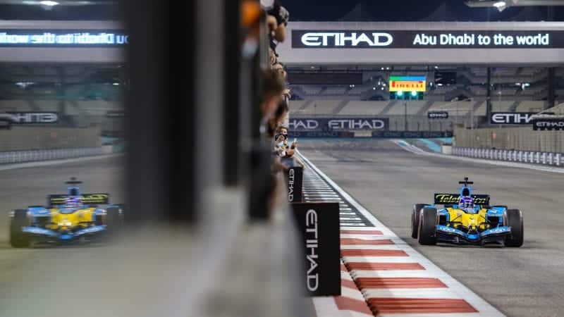 Mechanics watch as Fernando Alonso drives the Renault R25 in Abu Dhabi