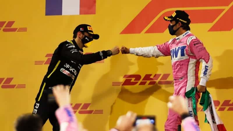 Sergio Perez manages a fist bump with Esteban Ocon on the podium after the 2020 Sakhir Grand Prix