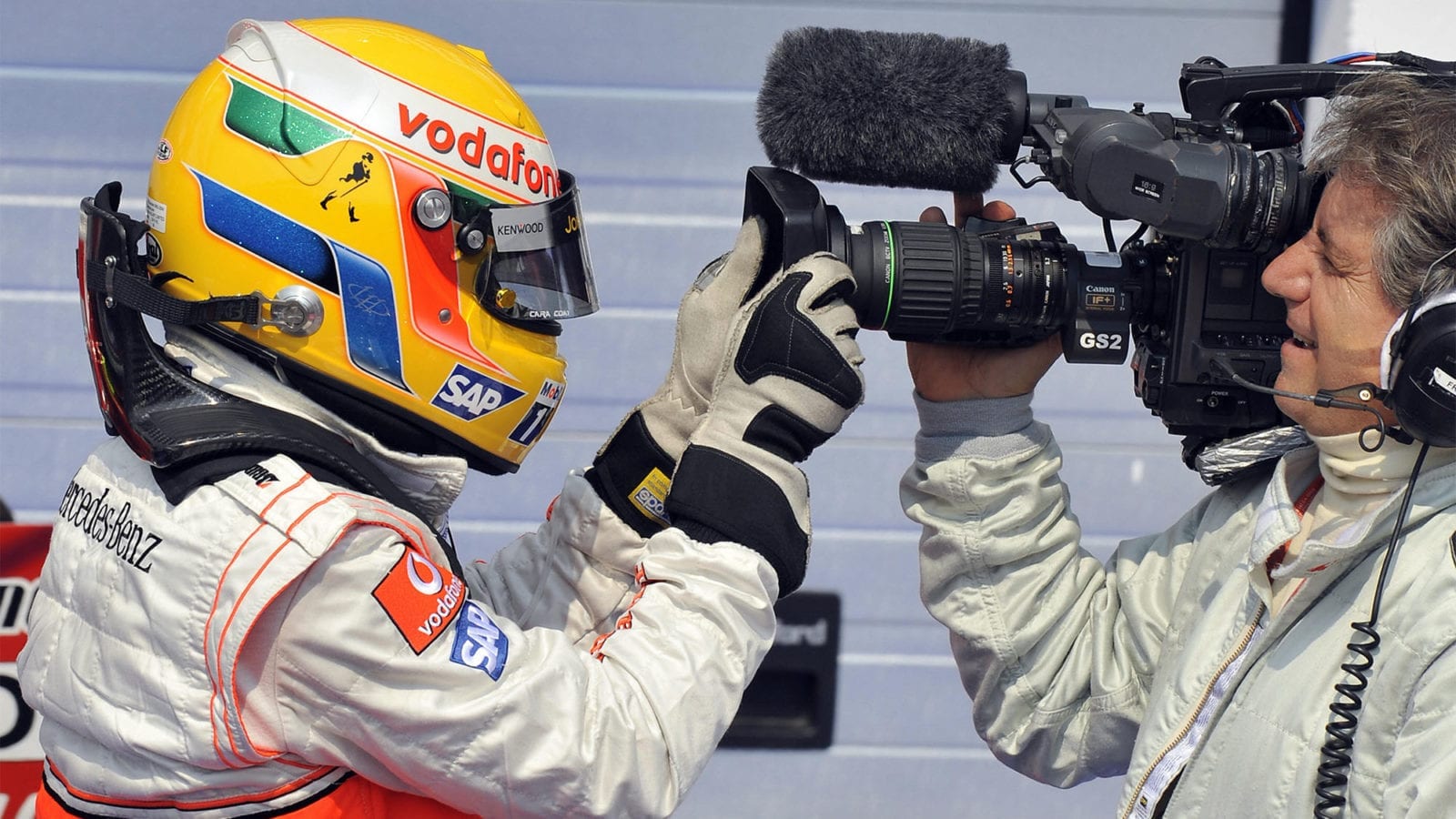 McLaren Mercedes' British driver Lewis Hamilton celebrates with a cameraman in the parc ferme of the Hungaroring racetrack on August 2, 2008 in Budapest after the qualifying session of the Formula One Hungarian Grand Prix. McLaren Mercedes' British driver Lewis Hamilton took the pole position ahead of his Finnish team mate Heikki Kovalainen and Ferrari Brazilian's driver Felipe Massa.