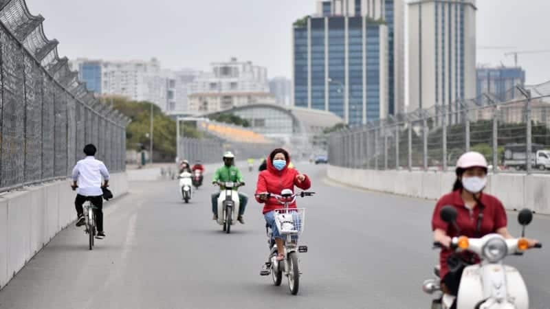 Moped and bicycle riders travel on the Hanoi Street Circuit in Vietnam