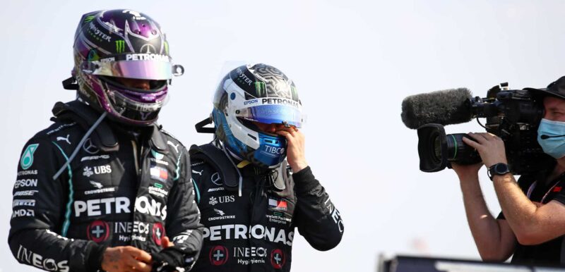 A cameraman follows Mercedes' British driver Lewis Hamilton (L) and Mercedes' Finnish driver Valtteri Bottas (C) as they walk to the podium at the end of the race during the F1 70th Anniversary Grand Prix at Silverstone on August 9, 2020 in Northampton. - The race commemorates the 70th anniversary of the inaugural world championship race, held at Silverstone in 1950. (Photo by Bryn Lennon / POOL / AFP) (Photo by BRYN LENNON/POOL/AFP via Getty Images)