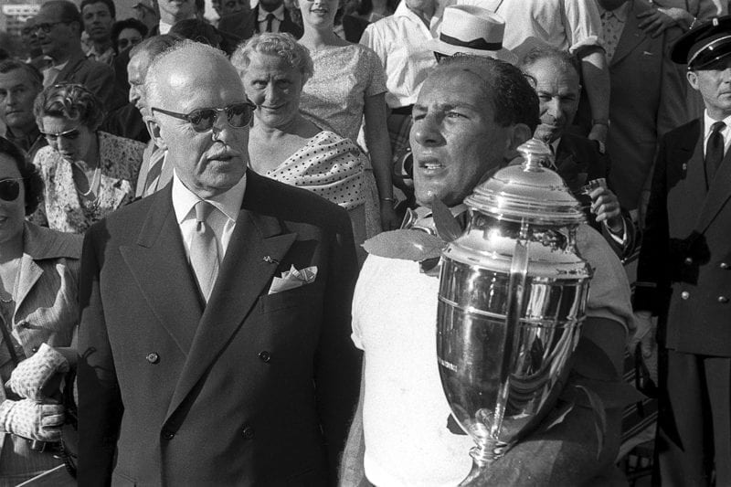 Stirling Moss holds the winner's trophy after victory in the 1956 Monaco Grand Prix