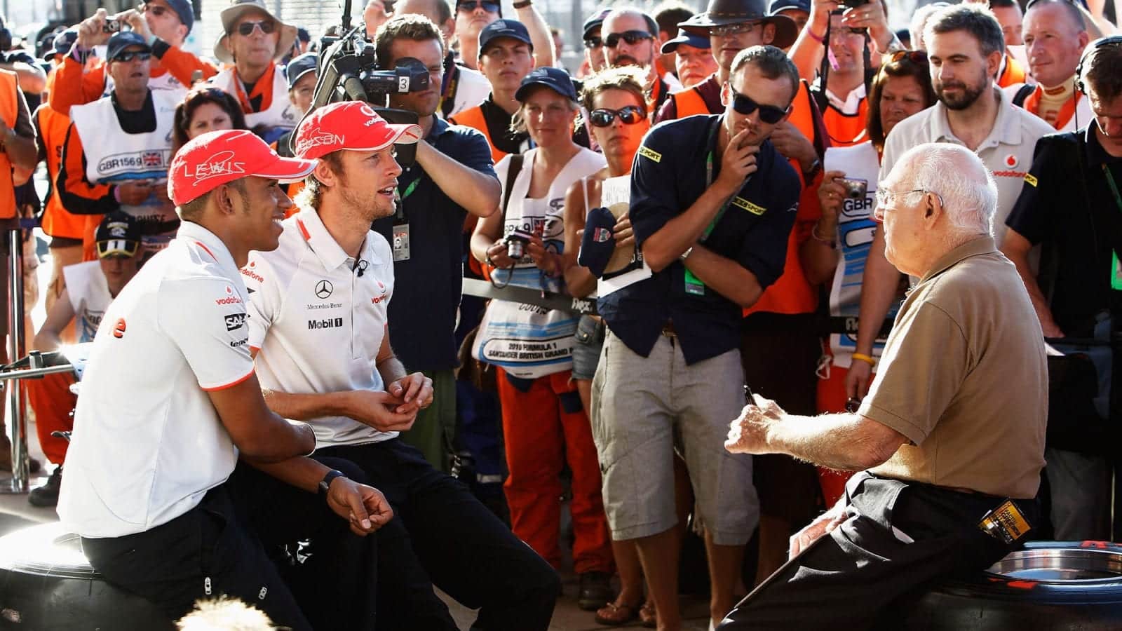 NORTHAMPTON, UNITED KINGDOM - JULY 10: Lewis Hamilton of Great Britain and McLaren Mercedes and Jenson Button of Great Britain and McLaren Mercedes are interviewed by Murray Walker following qualifying for the British Formula One Grand Prix at Silverstone Circuit on July 10, 2010, in Northampton, England. (Photo by Hoch Zwei/Getty Images)