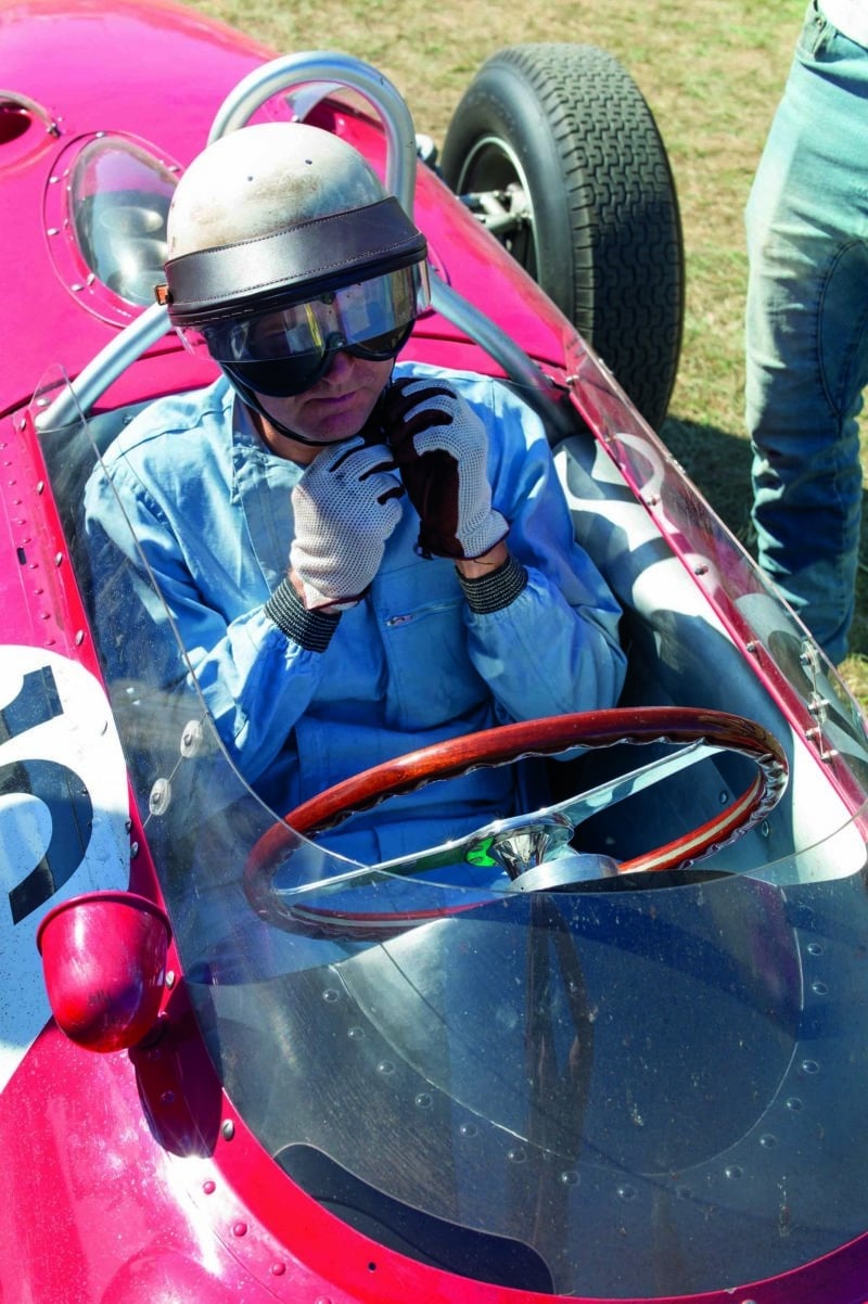 Derek Hill adjusting his helmet strap in the Sharknose Ferrari 156