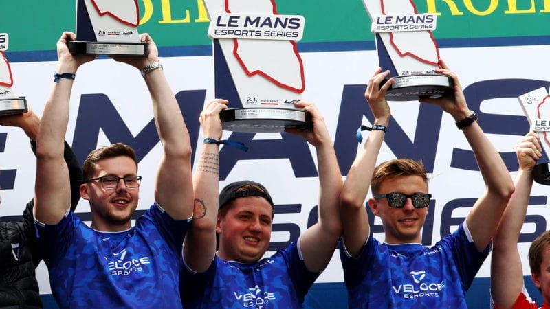 LE MANS, FRANCE - JUNE 15: (L-R) David Kelly (Sauber Dave) , Noah Schmitz (Veloce Virus) and James Baldwin (Veloce Jaaames) of Team Veloce celebrate on the podium after winning the Le Mans Esports Series Super Finale in the Fan Zone at the Circuit de la Sarthe on June 15, 2019 in Le Mans, France. (Photo by Ker Robertson/Getty Images)
