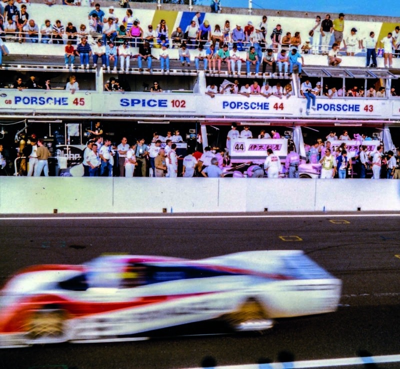 Porsche 962C speeds past the pits at the 1990 Le Mans 24 Hours