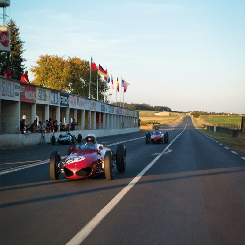 Sharknose Ferrari 156s driving past the Reims pits