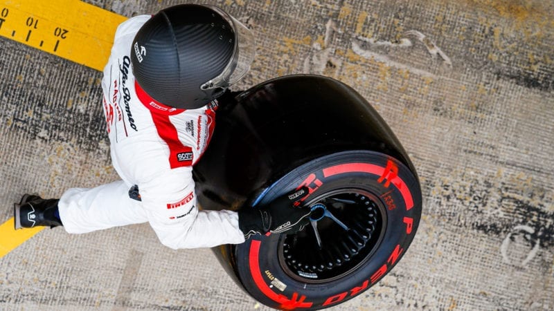 F1 mechanic carries a Pirelli tyre