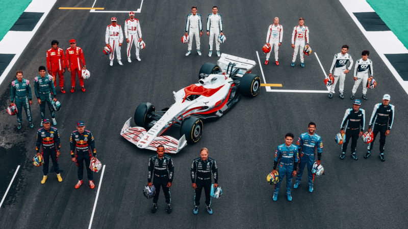F1 2022 car with F1 drivers from different teams surrounding it
