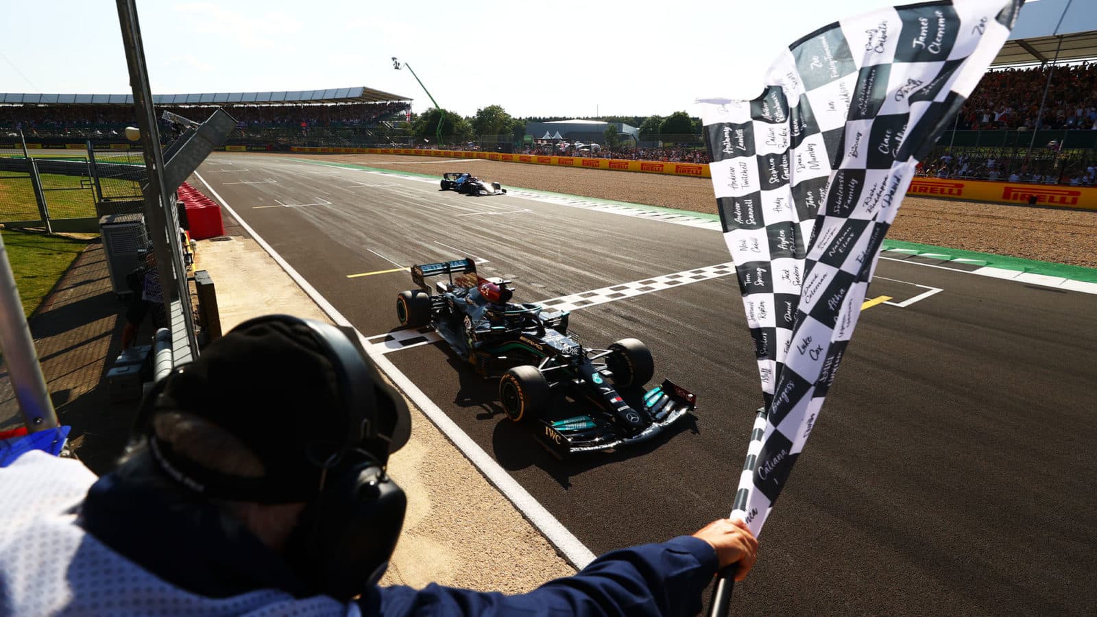NORTHAMPTON, ENGLAND - JULY 18: Race winner Lewis Hamilton of Great Britain driving the (44) Mercedes AMG Petronas F1 Team Mercedes W12 takes the chequered flag during the F1 Grand Prix of Great Britain at Silverstone on July 18, 2021 in Northampton, England. (Photo by Dan Istitene - Formula 1/Formula 1 via Getty Images)