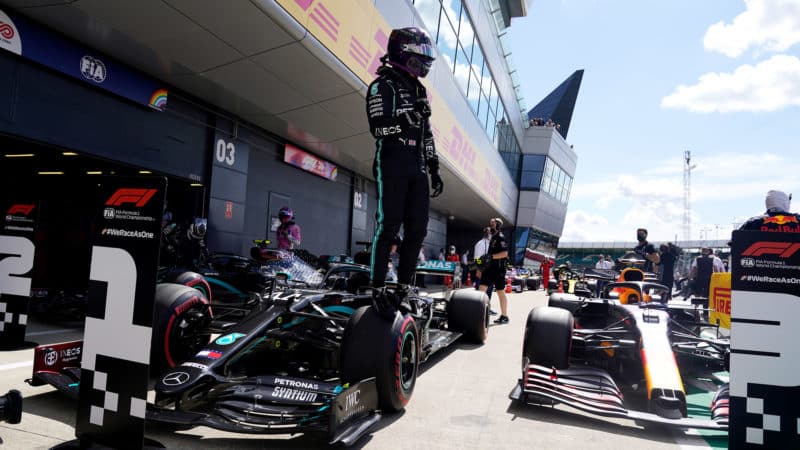 Lewis Hamilton stands on his Mercedes after qualifying on pole for the 2021 British Grand Prix