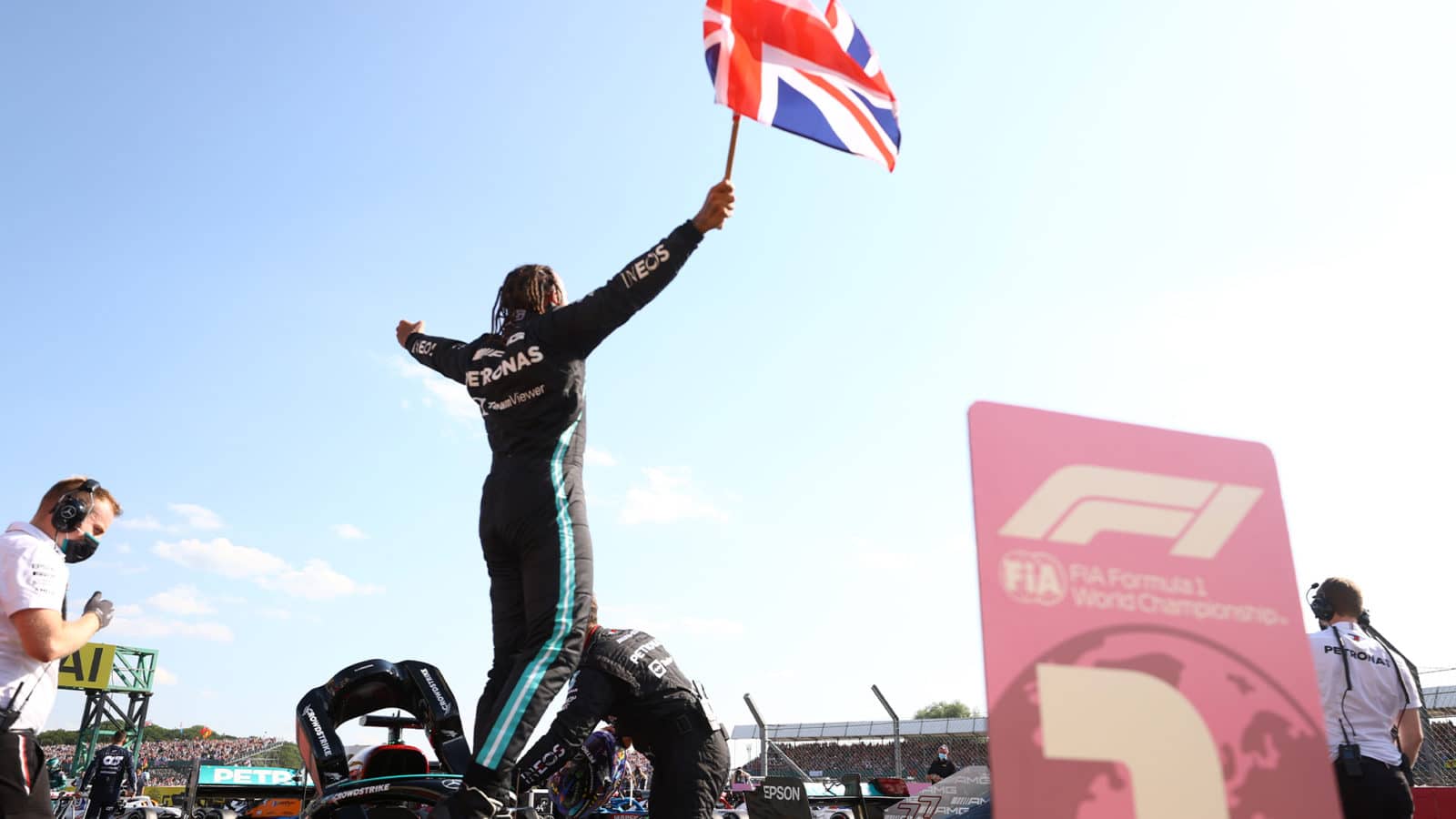 Lewis Hamilton waves the Union Jack in front of a Silverstone crowd after winning the 2021 British Grand Prix