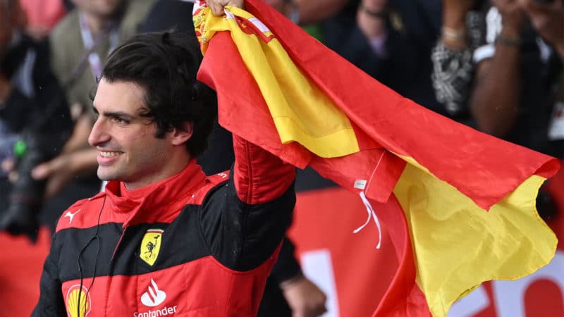Carlos Sainz wabves the Spanish flag after winning the 2022 British Grand Prix