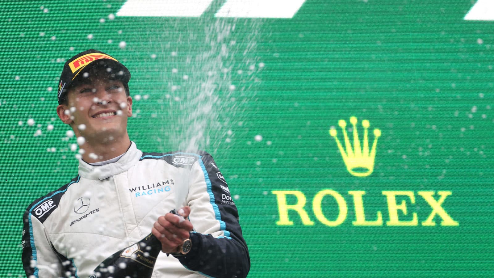 George Russell sprays champagne on the podium after the 2021 Belgian Grand Prix