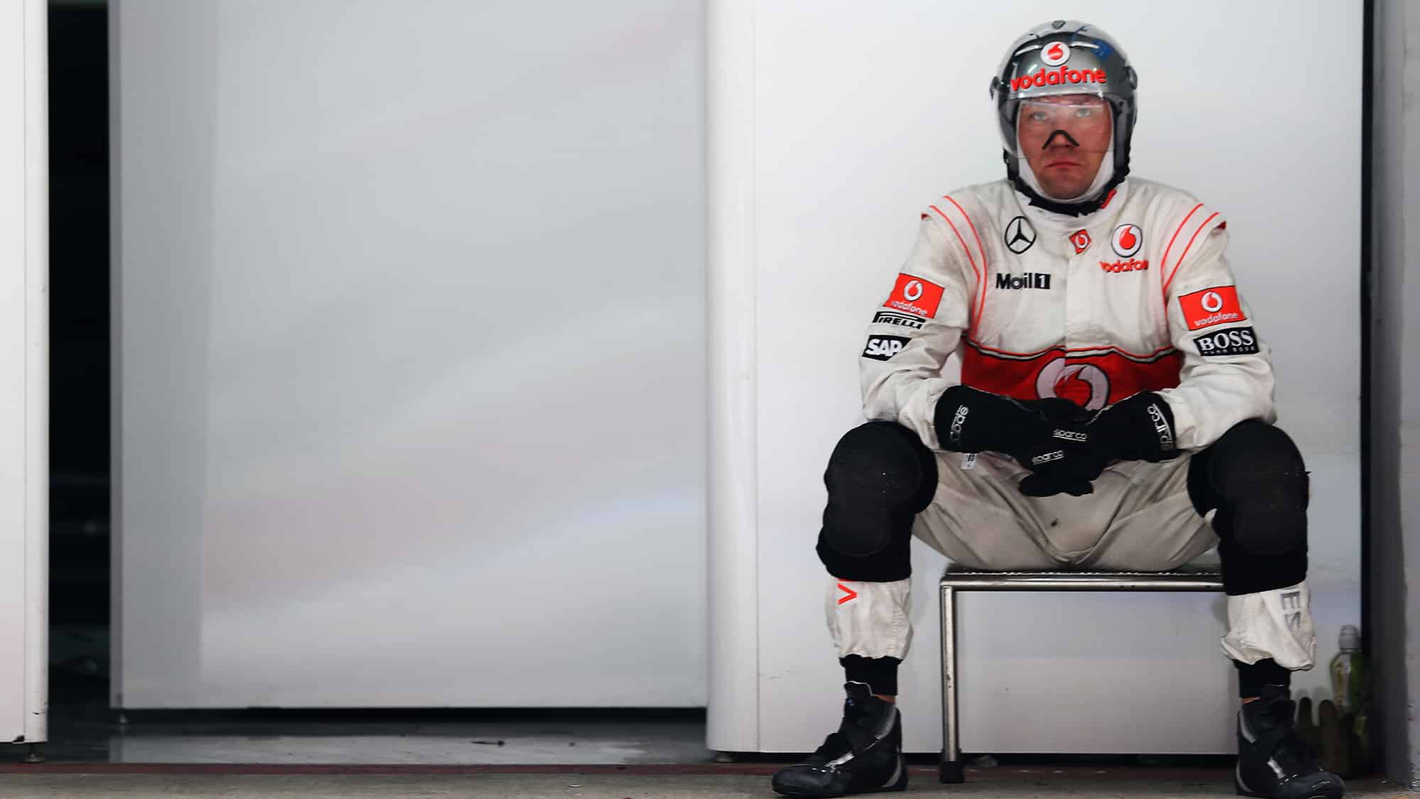 McLaren mechanic sits in the garage