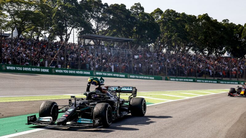 Lewis Hamilton waves a brazilian flag from his mercedes