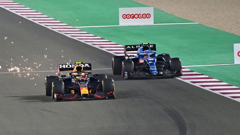 Red Bull's Mexican driver Sergio Perez (L) overtakes Alpine's French driver Esteban Ocon during the Qatari Formula One Grand Prix at the Losail International Circuit, on the outskirts of the capital city of Doha, on November 21, 2021. (Photo by ANDREJ ISAKOVIC / AFP) (Photo by ANDREJ ISAKOVIC/AFP via Getty Images)