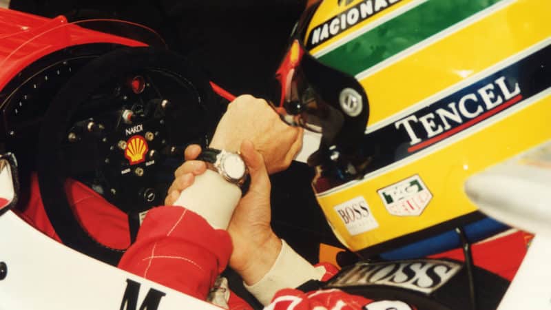 Ayrton Senna looking at his watch in McLaren cockpit