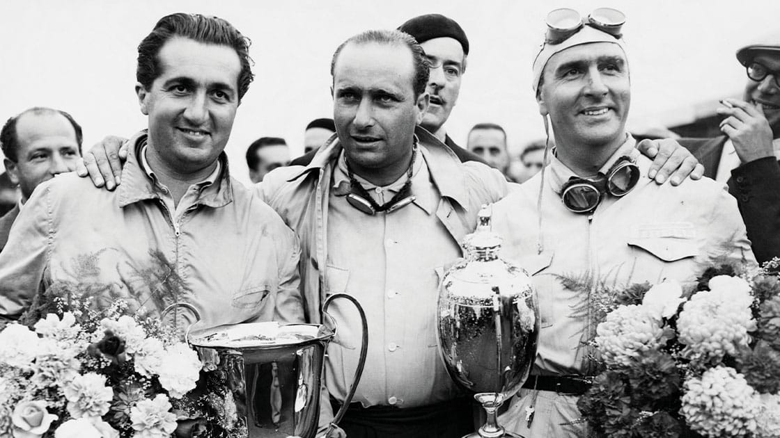 Juan-Fangio-stands-between-Alberto-Ascari-and-Guiseppe-Farina-who-hold-their-trophies-and-bouquets-after-the-auto-race-at-Silverstone.-Photo-by-%C2%A9-Hulton-Deutsch-CollectionCORBISCorbis-via-Getty-Images-.jpg