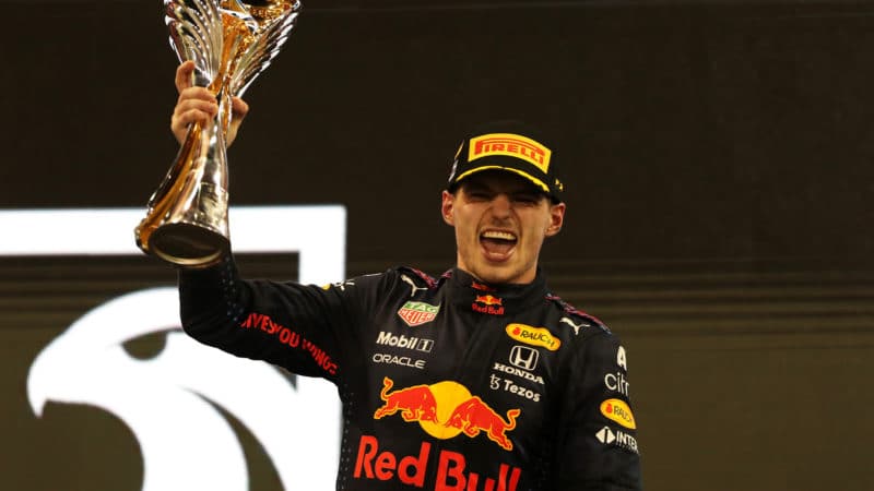 Max Verstappen celebrates winning the 2021 F1 championship on the podium at Abu Dhabi