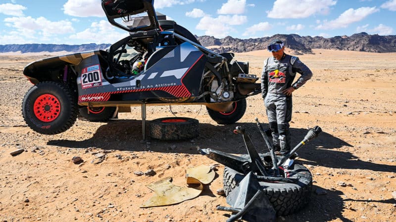 Stéphane Peterhansel inspects his damaged Audi at Dakar 2022