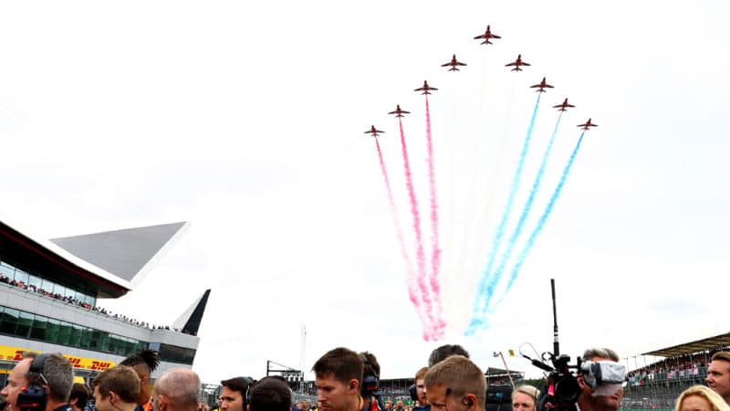 NORTHAMPTON, ENGLAND - JULY 14: The Red Arrows perform an aerobatics display above the Red Bull Racing team on the grid before the F1 Grand Prix of Great Britain at Silverstone on July 14, 2019 in Northampton, England. (Photo by Mark Thompson/Getty Images)