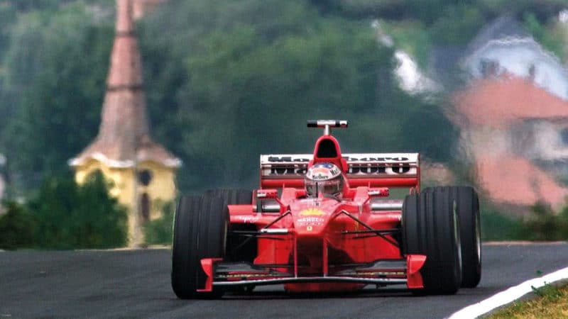 German Ferrari driver Michael Schumacher steers his car in front of the church of Mogyorod, 14 August on the Hungaroring racetrack in Budapest, during the first free practice sessions of the formula one Grand Prix of Hungary scheduled on 16 August. Schumacher set the third best time. (ELECTRONIC IMAGE) (Photo by PIERRE VERDY / AFP) (Photo by PIERRE VERDY/AFP via Getty Images)