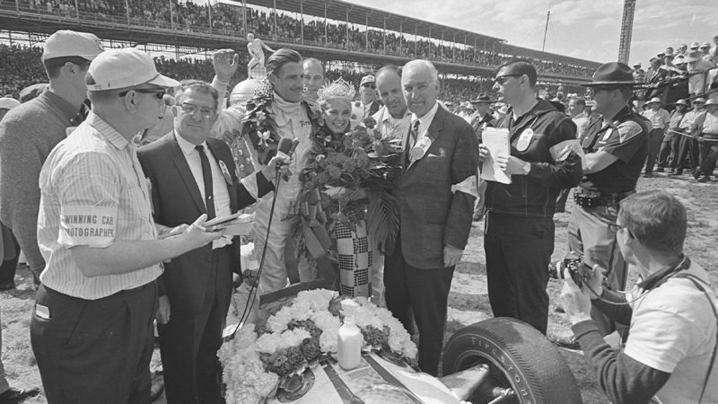 1966: Graham Hill celebrates victory in the Indianapolis 500 motor race driving a Lola car. The trophy can just be seen rising behind him. Mandatory Credit: Allsport Hulton/Archive