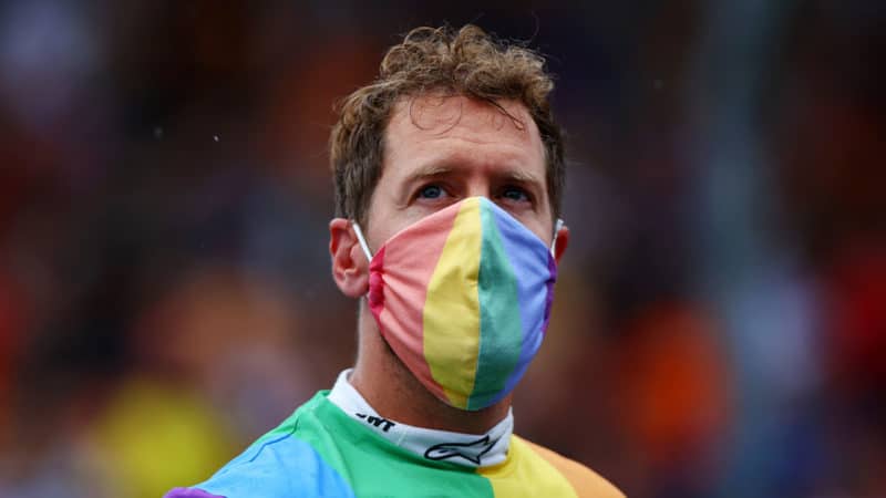 BUDAPEST, HUNGARY - AUGUST 01: Sebastian Vettel of Germany and Aston Martin wears a rainbow coloured t-shirt and face mask as he looks on from the grid before the F1 Grand Prix of Hungary at Hungaroring on August 01, 2021 in Budapest, Hungary. (Photo by Dan Istitene - Formula 1/Formula 1 via Getty Images)