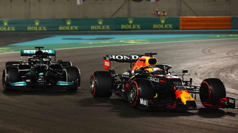 ABU DHABI, UNITED ARAB EMIRATES - DECEMBER 12: Max Verstappen of the Netherlands driving the (33) Red Bull Racing RB16B Honda overtakes Lewis Hamilton of Great Britain driving the (44) Mercedes AMG Petronas F1 Team Mercedes W12 to claim a dramatic victory on the final lap of the race to win his first Formula 1 World Title during the F1 Grand Prix of Abu Dhabi at Yas Marina Circuit on December 12, 2021 in Abu Dhabi, United Arab Emirates. (Photo by Joe Portlock - Formula 1/Formula 1 via Getty Images)