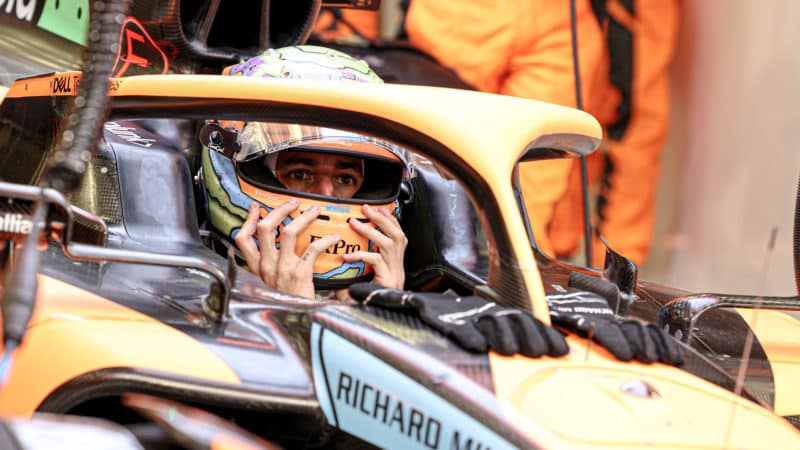 Daniel Ricciardo holds his helmet in McLaren cockpit