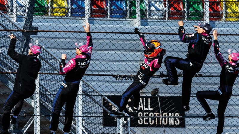 Helio Castroneves and crew climb the fence at 2022 Daytona 24