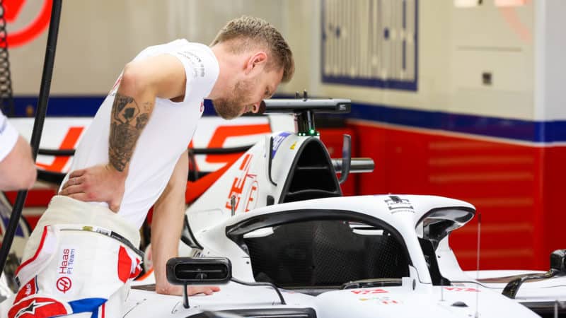Kevin Magnussen looks at cockpit of 2022 Haas F1 car