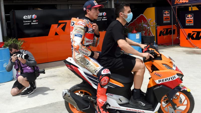 Marc Marquez returns to the paddock on a scooter after highside crash in Indonesia