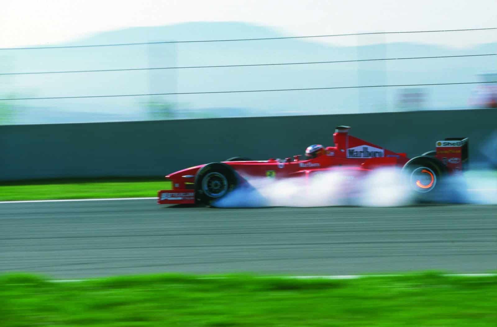 Michael-Schumacher-locks-up-Ferrari-F300-in-a-cloud-of-smoke-scaled
