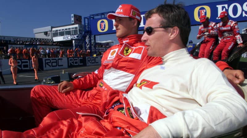 Eddie Irvine sits next to Michael Schumacher at the British Grand Prix