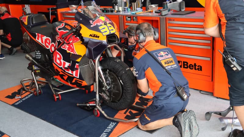 KTM mechanics finish changing wheel on MotoGP bike