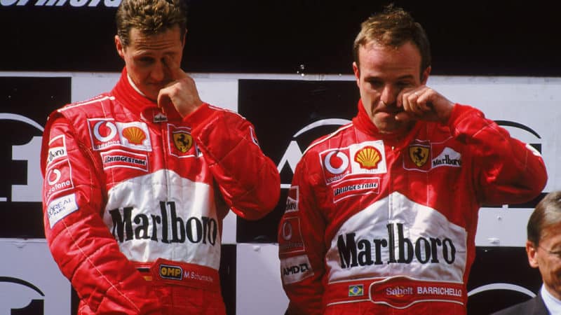 A1 RING - MAY 12: Race winner Ferrari driver Michael Schumacher of Germany and runner-up Ferrari driver Rubens Barrichello of Brazil stand on the podium after the Austrian Formula One Grand Prix held at the A1 Ring in Spielberg, Austria on May 12, 2002. They swapped places on the podium as Barrichello led most of the race but under team orders let Schumacher overtake him on the last lap to win the race. (Photo by Tom Shaw/Getty Images)