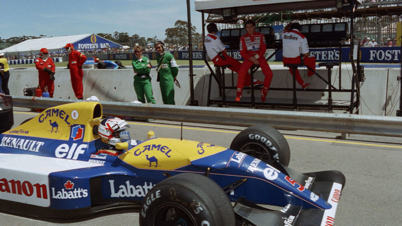 Brazilian Formula One driver Ayrton Senna (back seated, 2ndR) watches 92 British World Champion Nigel Mansell (in car) returning to his pit after the second qualifying practice session of the Australian Grand Prix on November 7, 1992 in Adelaide. - Mansell took the pole position while Senna will start in 2nd. (Photo by Toshifumi KITAMURA / AFP) (Photo credit should read TOSHIFUMI KITAMURA/AFP via Getty Images)