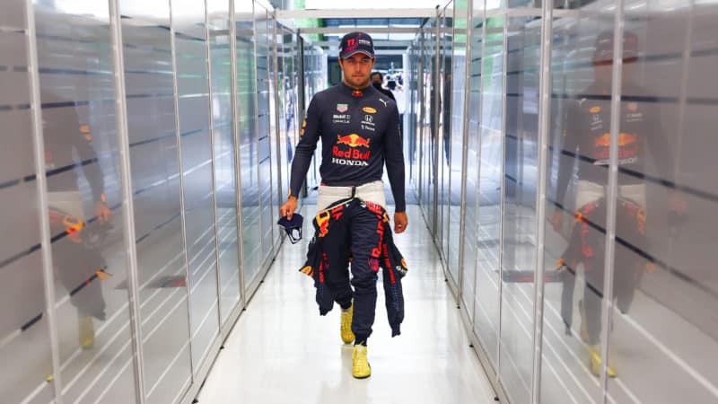 Sergio Perez walks into the Red Bull pit garage