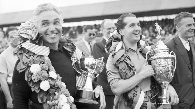 21st July 1952: Italian racing drivers Piero Taruffi (1906 - 1988, left) and Alberto Ascari (1918 - 1955) celebrate their triumph in the British Grand Prix at Silverstone. Ascari came in first and Taruffi took second place. (Photo by Express/Express/Getty Images)