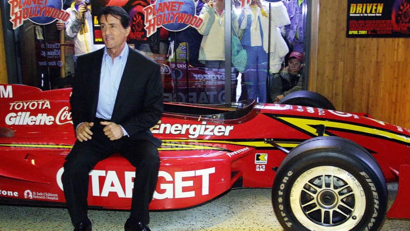 Sylvester Stallone with a replica Indycar from his film Driven